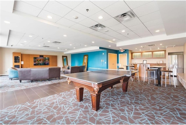 rec room with a tray ceiling, visible vents, and recessed lighting