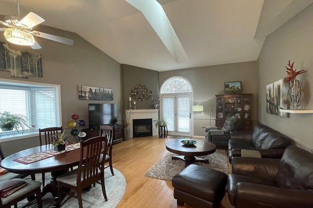 living room featuring ceiling fan, lofted ceiling, and light hardwood / wood-style floors