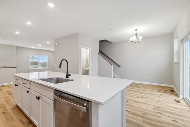 kitchen with sink, white cabinets, stainless steel dishwasher, a center island with sink, and light wood-type flooring