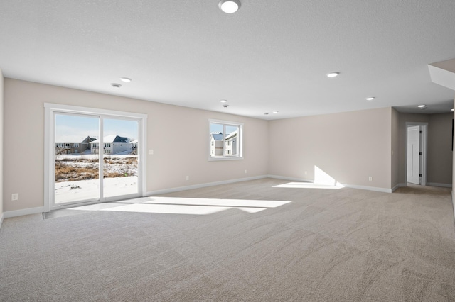 carpeted spare room with a textured ceiling