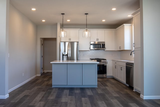 kitchen featuring dark wood-style floors, stainless steel appliances, decorative backsplash, white cabinetry, and a kitchen island