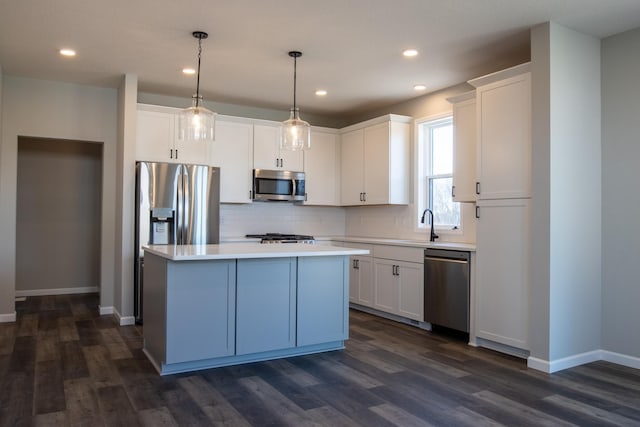 kitchen with stainless steel appliances, dark wood-style flooring, white cabinetry, light countertops, and tasteful backsplash