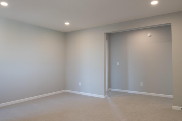 spare room featuring light carpet, baseboards, and recessed lighting