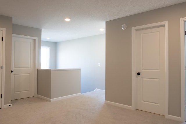 corridor with baseboards, recessed lighting, an upstairs landing, and light colored carpet