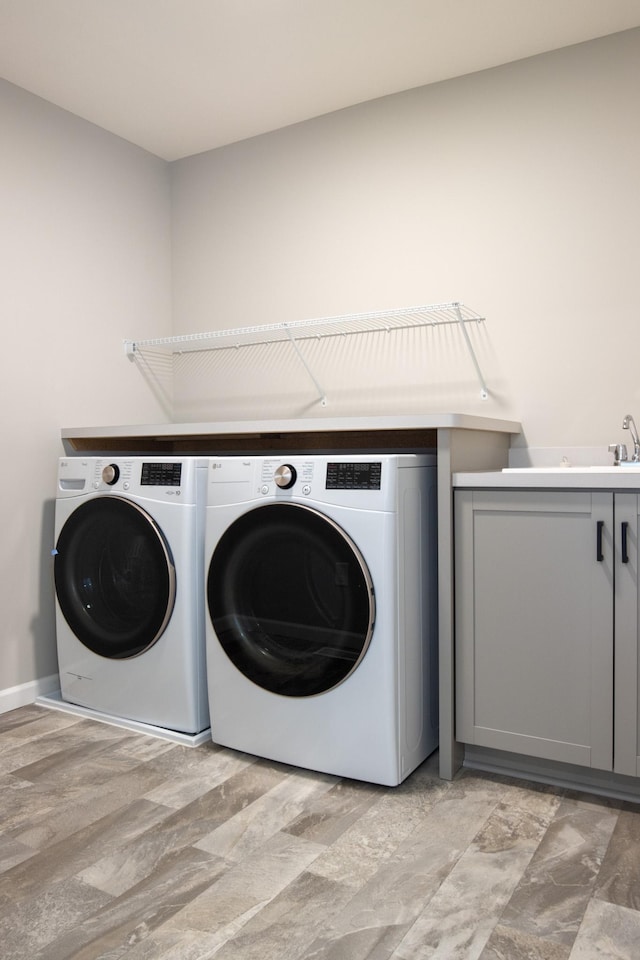 washroom featuring cabinet space and independent washer and dryer