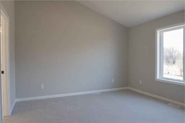 empty room featuring visible vents, light carpet, and baseboards