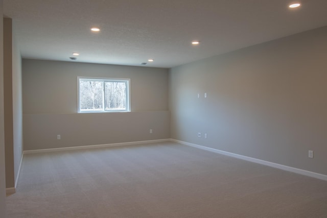 spare room with light carpet, baseboards, and recessed lighting