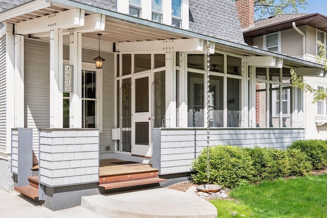 entrance to property with mansard roof and a shingled roof