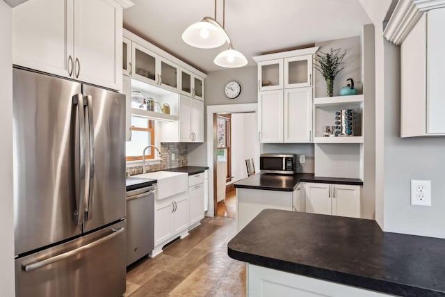 kitchen featuring glass insert cabinets, stainless steel appliances, open shelves, and dark countertops