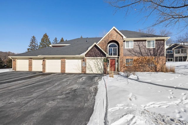 view of front of property featuring brick siding and community garages