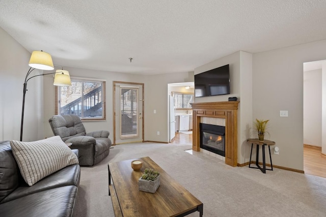 living area with light colored carpet, a fireplace, and a textured ceiling