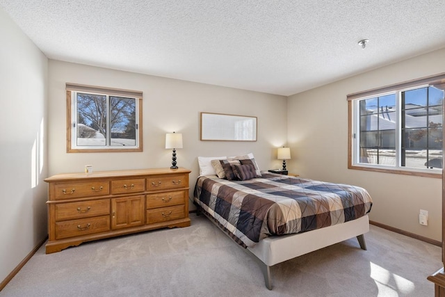 bedroom with light carpet, a textured ceiling, and baseboards