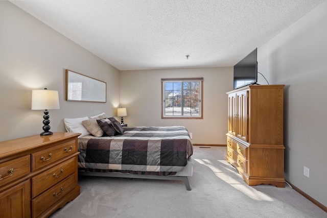 bedroom featuring light carpet, a textured ceiling, and baseboards