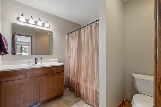 full bath with a textured ceiling, a shower with shower curtain, vanity, and toilet