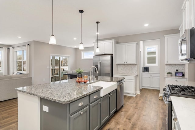 kitchen featuring sink, gray cabinetry, a center island with sink, appliances with stainless steel finishes, and white cabinets