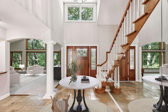 foyer entrance featuring a high ceiling and ornate columns