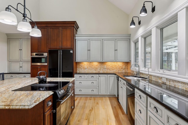 kitchen with decorative light fixtures, tasteful backsplash, sink, dark stone countertops, and black appliances