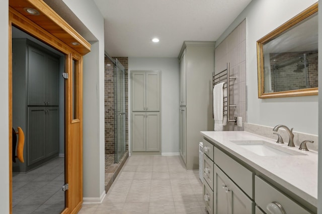 bathroom featuring vanity, a shower with shower door, and tile patterned floors