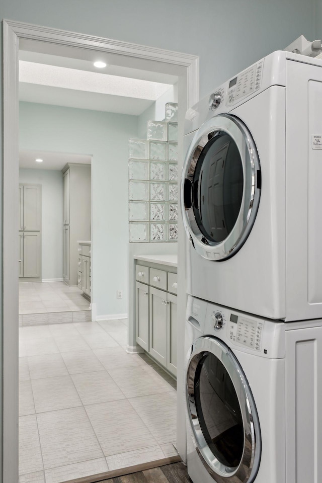 laundry room with stacked washer and dryer and light tile patterned floors