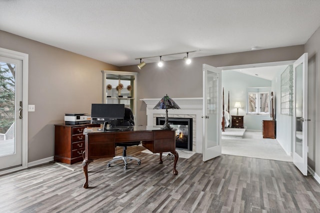 home office featuring plenty of natural light, a textured ceiling, and a high end fireplace