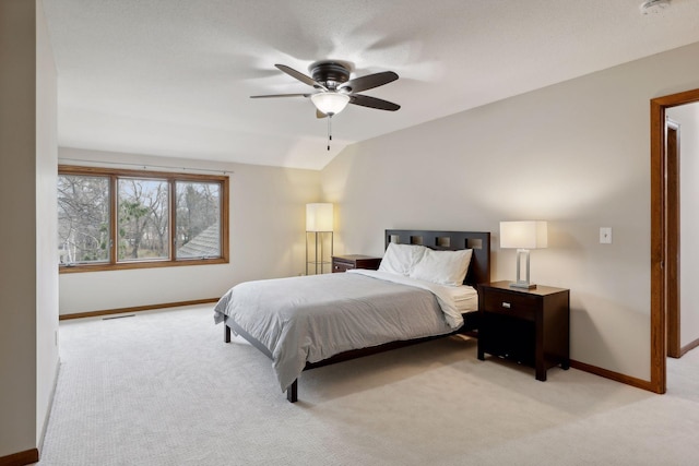 bedroom featuring ceiling fan, vaulted ceiling, and light carpet