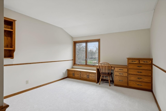 unfurnished office featuring light carpet and vaulted ceiling