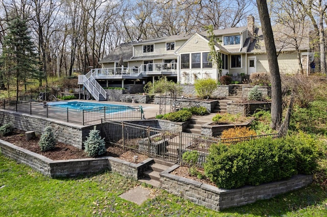 back of house with a pool side deck and a sunroom