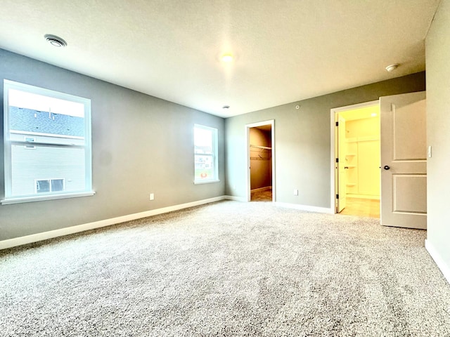13643 Kaylemore Trl, Rosemount, MN 55068 - unfurnished bedroom featuring carpet flooring, visible vents, a closet, baseboards, and a walk in closet