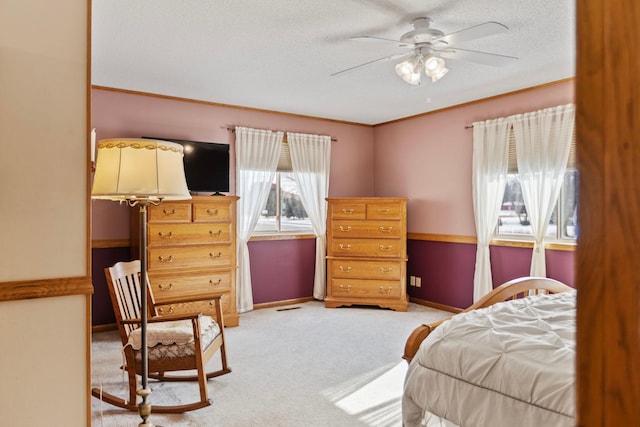 carpeted bedroom with crown molding, ceiling fan, and a textured ceiling