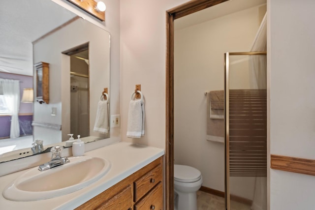 bathroom featuring vanity, an enclosed shower, and toilet