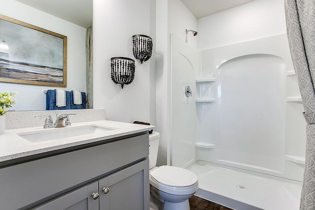 bathroom featuring vanity, a shower, and toilet