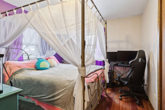 bedroom with dark hardwood / wood-style floors and a textured ceiling