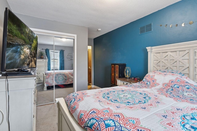 bedroom featuring a closet, light carpet, and a textured ceiling