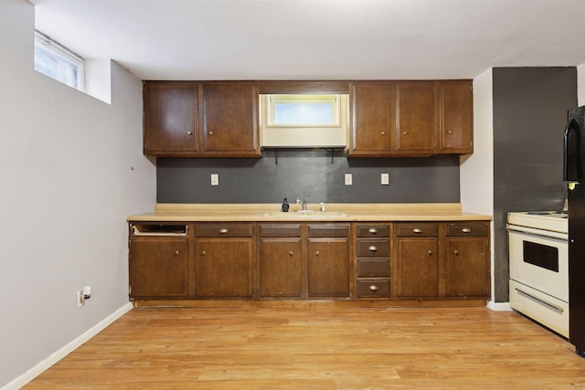 kitchen featuring sink, light hardwood / wood-style floors, and white range with electric stovetop