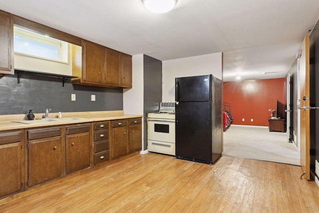 kitchen with light hardwood / wood-style flooring, sink, white range with electric stovetop, and black fridge