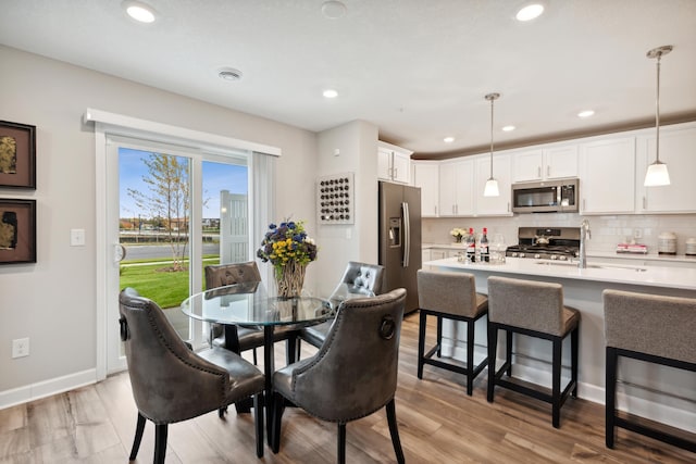 dining room featuring sink and light hardwood / wood-style flooring