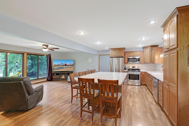 kitchen featuring a breakfast bar, sink, a center island, light hardwood / wood-style flooring, and stainless steel appliances