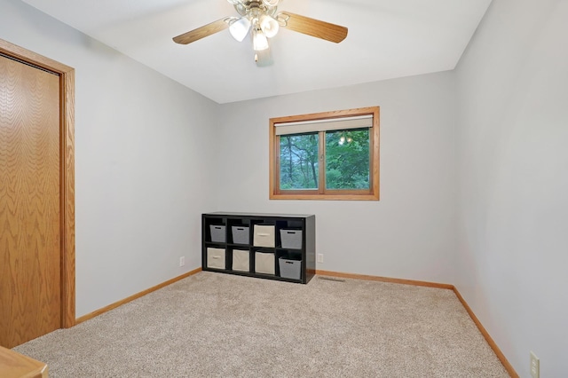 unfurnished room featuring ceiling fan and carpet flooring