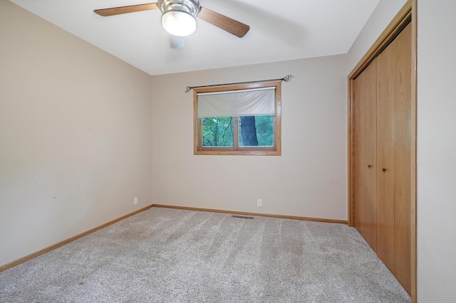 unfurnished bedroom with carpet floors, ceiling fan, and a closet