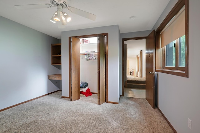 unfurnished bedroom with light colored carpet, a closet, and ceiling fan