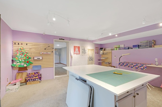 kitchen featuring track lighting, light carpet, and a kitchen island