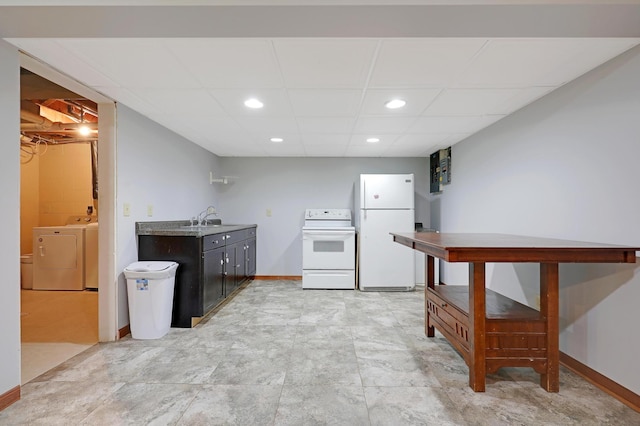 kitchen featuring white appliances, a paneled ceiling, sink, and washing machine and dryer