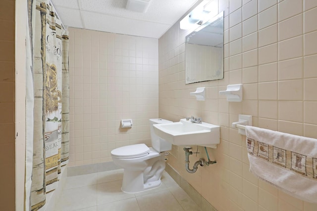 bathroom with sink, tile walls, walk in shower, toilet, and tile patterned floors