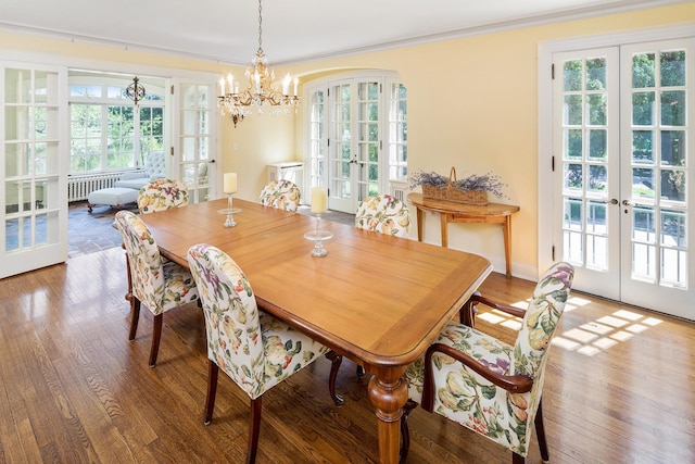 dining space featuring ornamental molding, hardwood / wood-style floors, a notable chandelier, and french doors