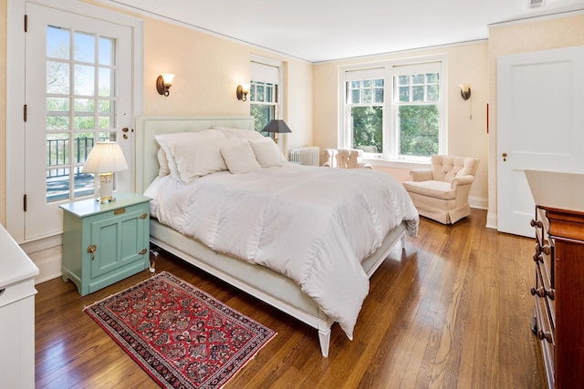 bedroom with crown molding, radiator, and dark hardwood / wood-style flooring