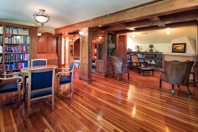 interior space with hardwood / wood-style flooring, beam ceiling, and decorative columns