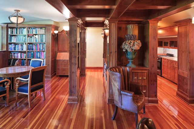 sitting room featuring ornate columns, hardwood / wood-style flooring, and beamed ceiling