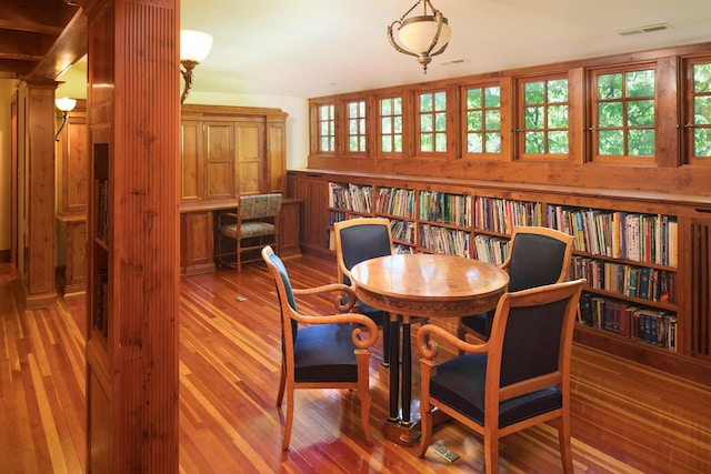 dining room featuring hardwood / wood-style floors, a wealth of natural light, and decorative columns