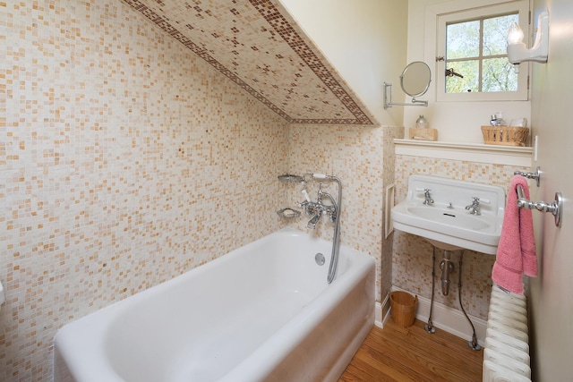 bathroom featuring a bath, sink, and hardwood / wood-style floors