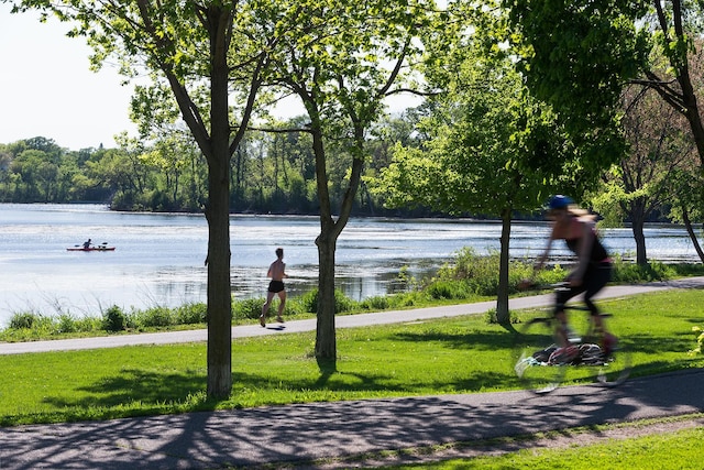 surrounding community featuring a water view and a lawn